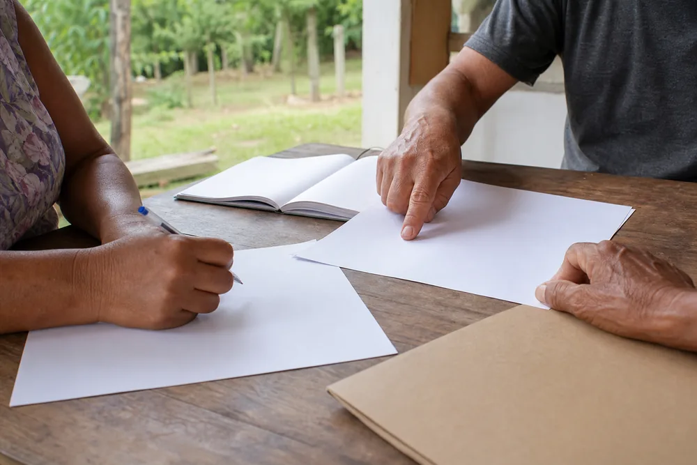 Pessoas revisando documentos sem identificação em mesa de atendimento rural