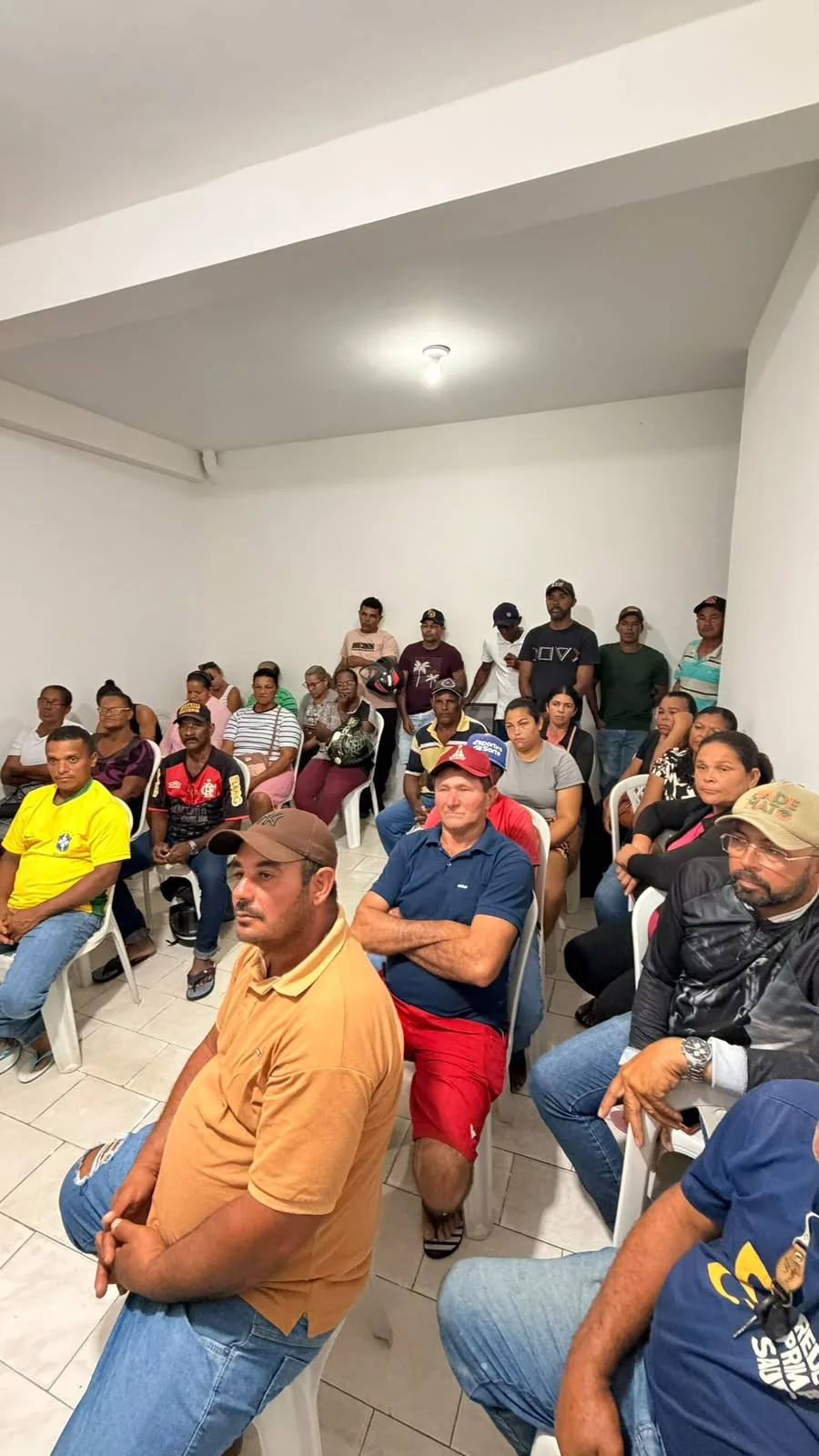 Grupo de agricultoras, agricultores e familiares reunidos em sala